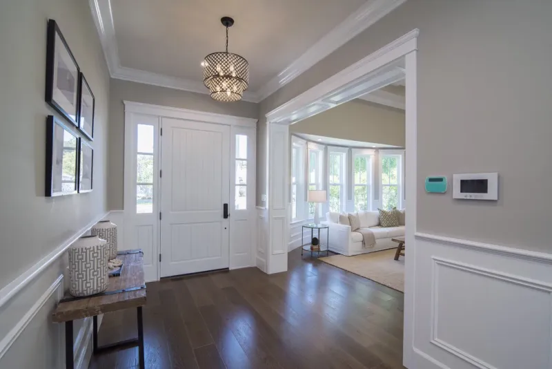 Front entry with an open door, wainscoting and a lantern pendant